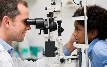 Ophthalmologist performing comprehensive eye examination on patient